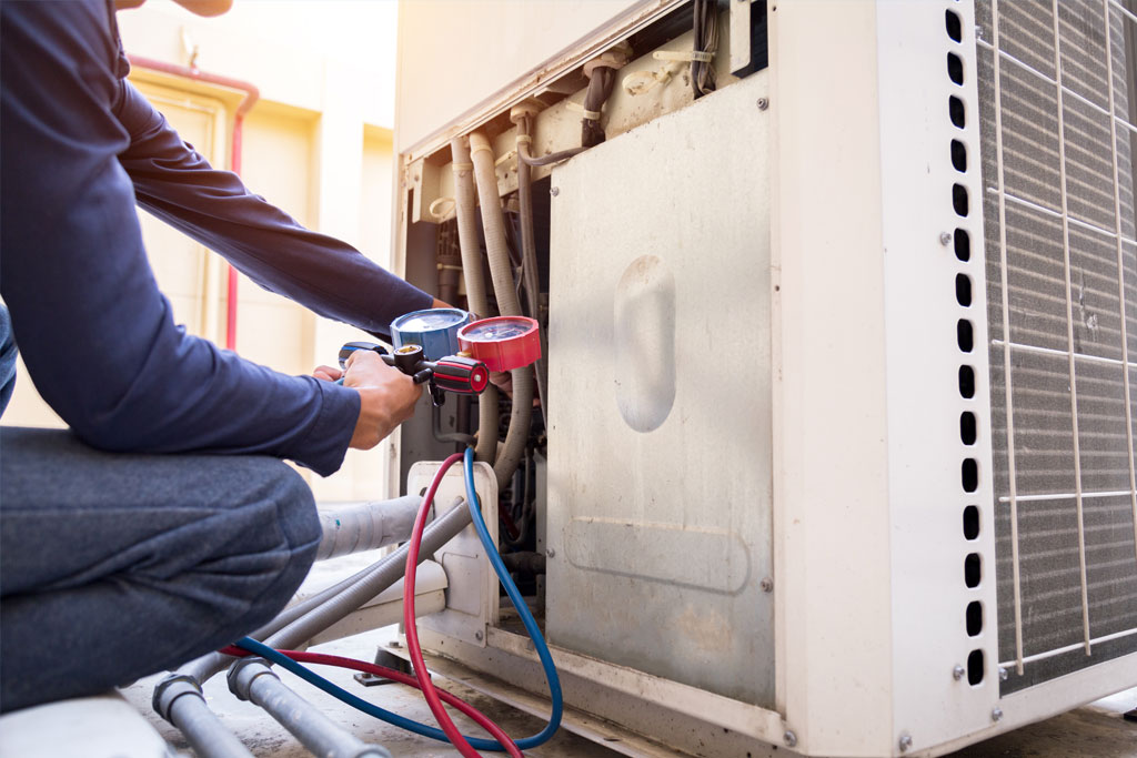 Técnico de aire acondicionado haciendo mantenimiento